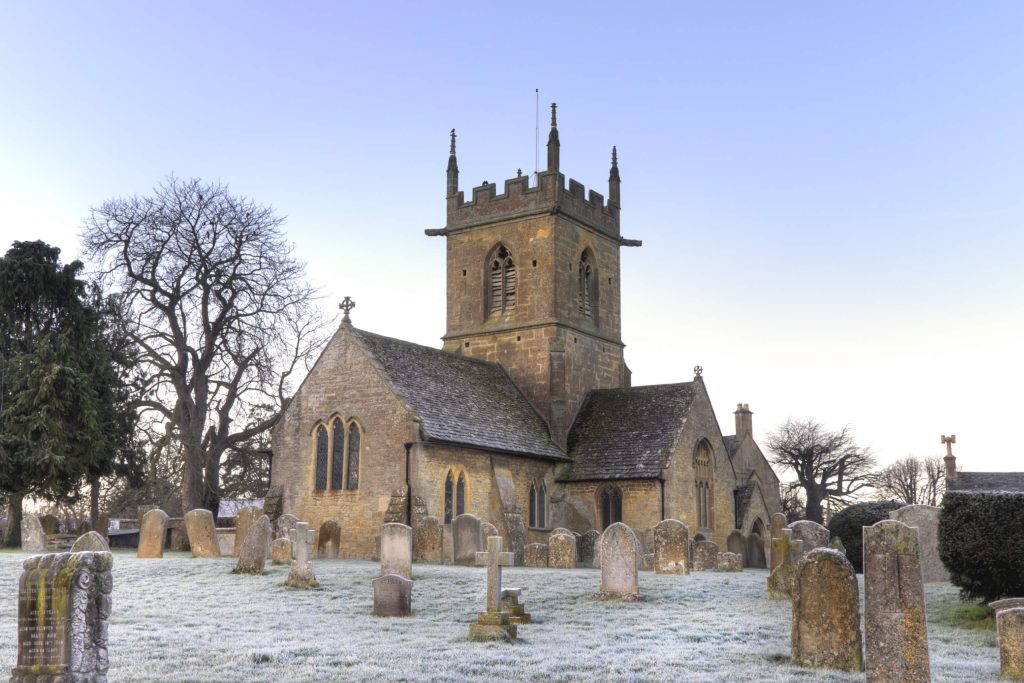 A church with and graveyard with frost settled on the ground